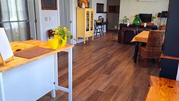 Une cuisine moderne dotée d’un plan de travail en bois, d’un four encastré et d’un coin repas avec une table et des chaises en bois.
