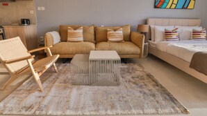 En stue med sofa, stol, sofabord og en seng.