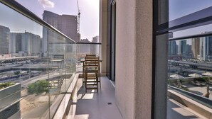 Ein Balkon mit Blick auf eine Stadtlandschaft, darunter Hochhäuser und ein Baukran.