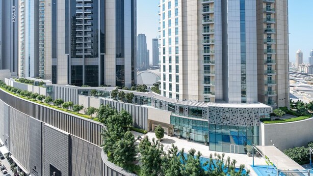 A high-rise residential building with a modern design, featuring balconies and large windows.