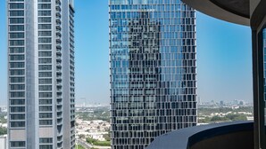 A high-rise building with a grid-like facade, surrounded by other tall buildings and a construction site in the foreground.