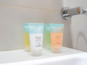 Trois tubes de lotion sur une étagère blanche.