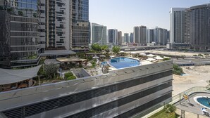 A high-rise building with a rooftop pool and outdoor seating area. - Apartment in Downtown Dubai Near Burj Khalifa (Dubai)