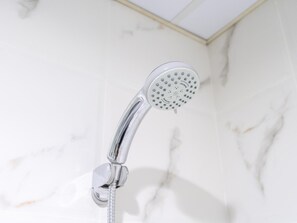 A modern showerhead with multiple spray settings, mounted on a wall with a marble-like texture. - Luxe 4bed Apt Dubai Marina JBR Pool by Belvilla (Dubai)