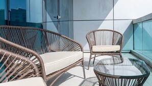 A modern balcony with wicker furniture and a glass table, featuring a cityscape view. - Luxe 4bed Apt Dubai Marina JBR Pool by Belvilla (Dubai)