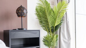 A modern bedroom with a black nightstand, a geometric lamp, and a large potted palm plant. - Luxe 4bed Apt Dubai Marina JBR Pool by Belvilla (Dubai)