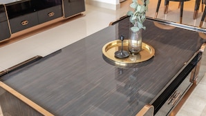A modern kitchen with a dark countertop, gold accents, and a decorative plant centerpiece. - 1BR Dlx City View Near Dubai Mall by Belvilla (Dubai)