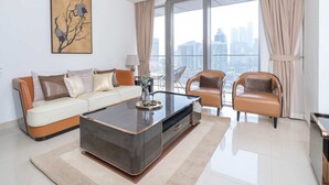 A modern living room with a sofa, armchairs, a coffee table, and a large window with curtains. - 1BR Dlx City View Near Dubai Mall by Belvilla (Dubai)