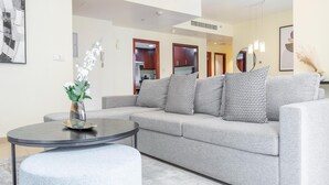 A modern living room with a grey sofa, a round coffee table, and a vase with white flowers.