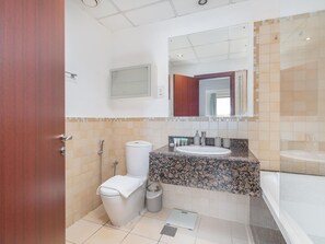 Ein modernes Badezimmer mit Toilette, Waschbecken und Badewanne.