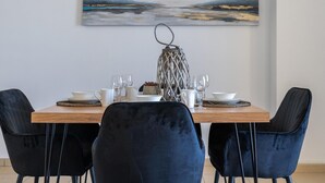 Un comedor con una mesa de madera, dos sillas negras y un farol decorativo.