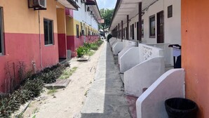 A corridor with rows of rooms, each with a window and air conditioning unit. - OYO 90981 Chenang Rest House 1 (Langkawi)