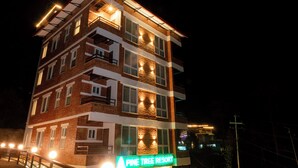 A multi-story building with a sign reading "Pine Tree Resort."