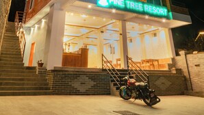 A multi-story building with a sign reading "Pine Tree Resort".