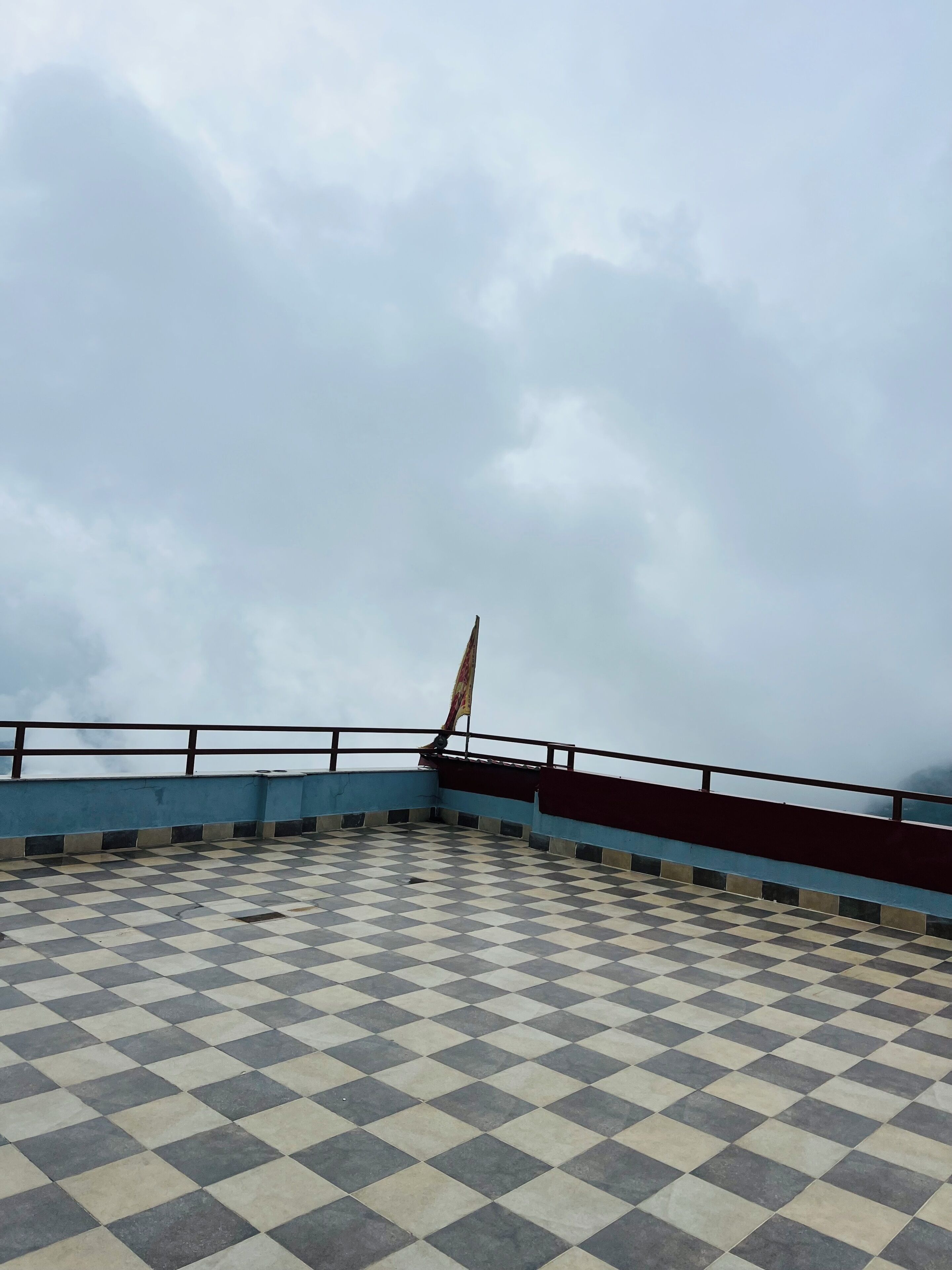 A checkered floor with a railing and a flag.