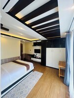 A modern bedroom with a bed, a desk, and a wardrobe.