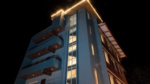 A multi-story building with a modern design, featuring balconies and large windows.