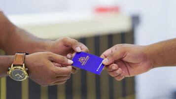 Una persona entregando una tarjeta morada a otra.
