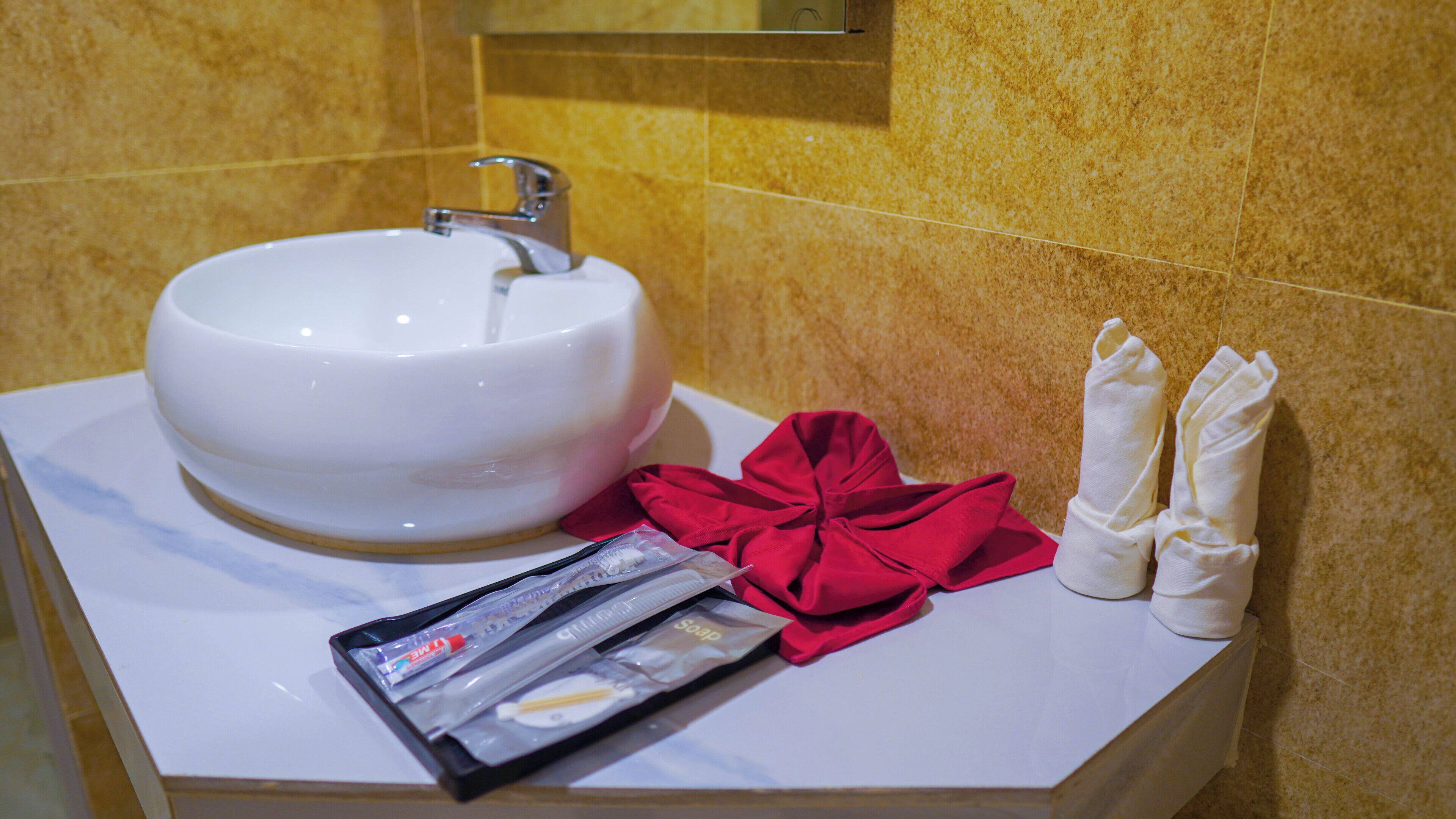 A bathroom sink with toiletries and towels.