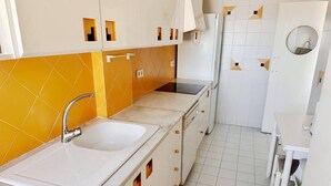 A kitchen with a double sink, a stove, and a refrigerator. - Beautiful and comfortable apartment  with communal pool in Denia, Costa Blanca, Spain for 4 persons (Denia)