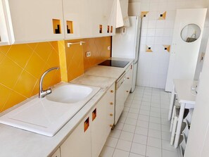 Una cocina con un lavamanos doble, una estufa y un refrigerador.