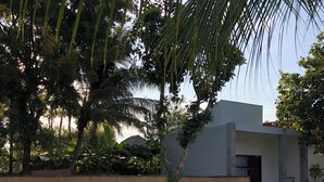 Una piscina con sillones de descanso y un edificio moderno al fondo.