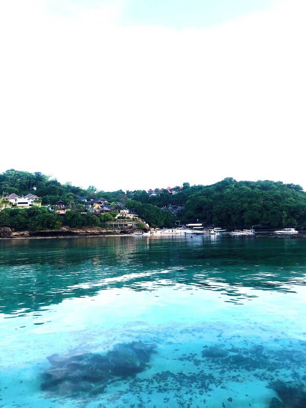 A coastal area with houses on a hillside and boats on the water. - Mahadinusa Lembongan (Lembongan Island)