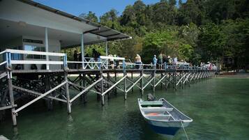 A pier with a dive center and people on it.