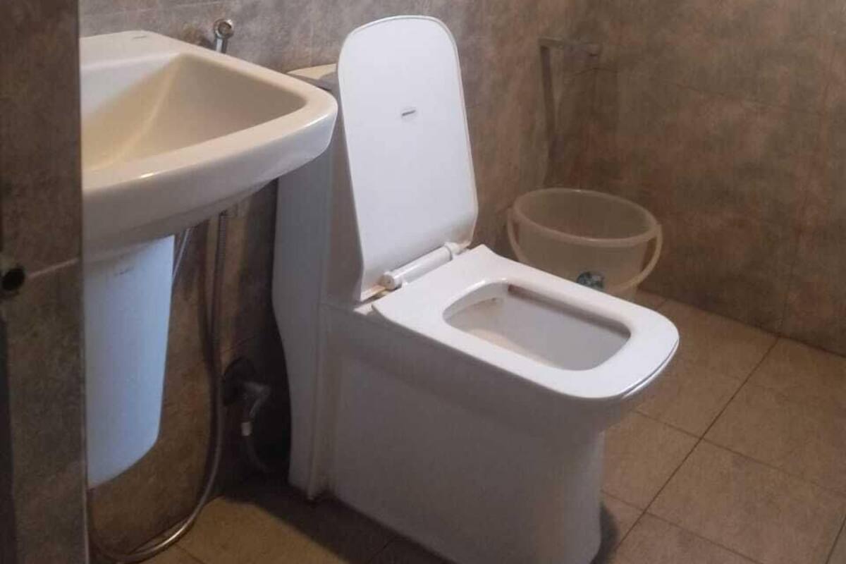 Baño pequeño con inodoro, lavamanos y ducha.