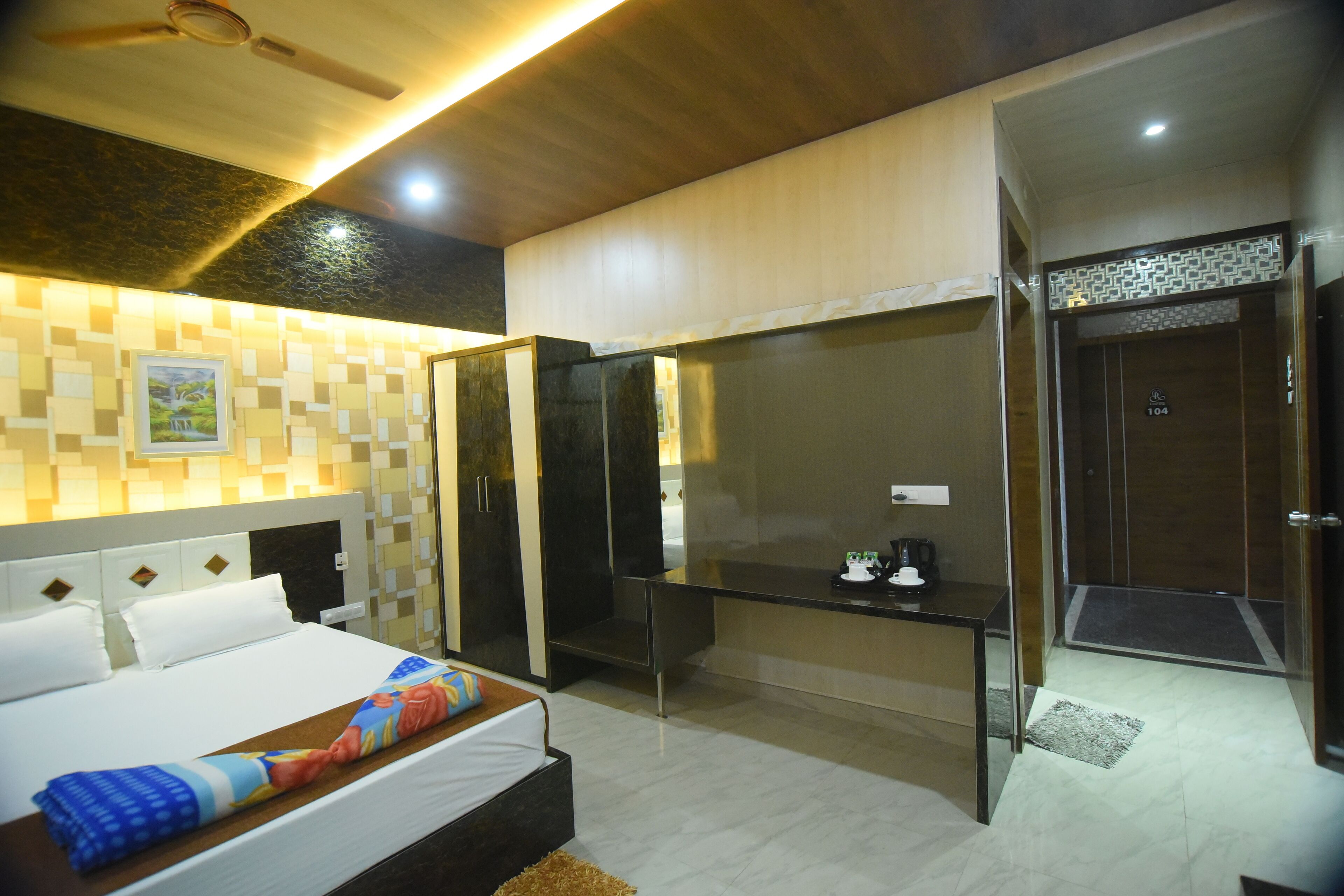 Habitación de hotel moderna con cama, escritorio y zona de ducha.