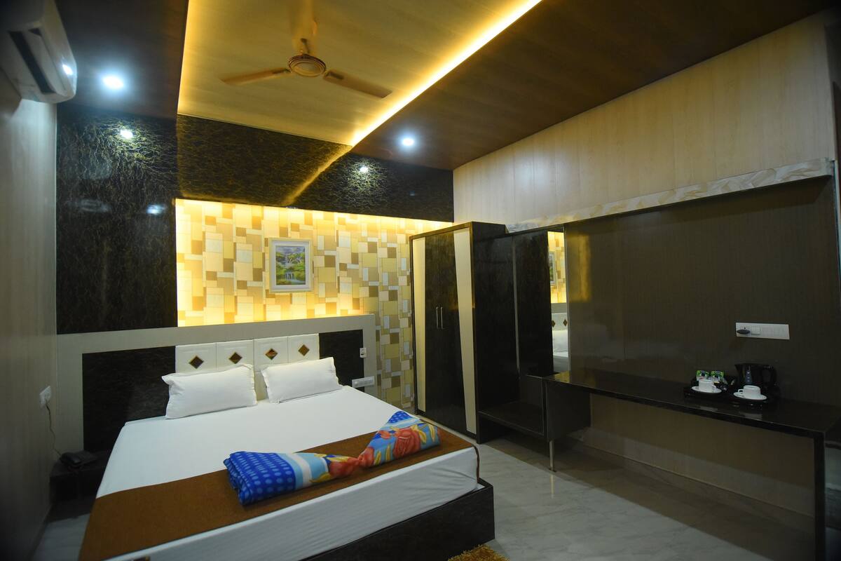 A modern hotel room with a large bed, a desk, and a television.