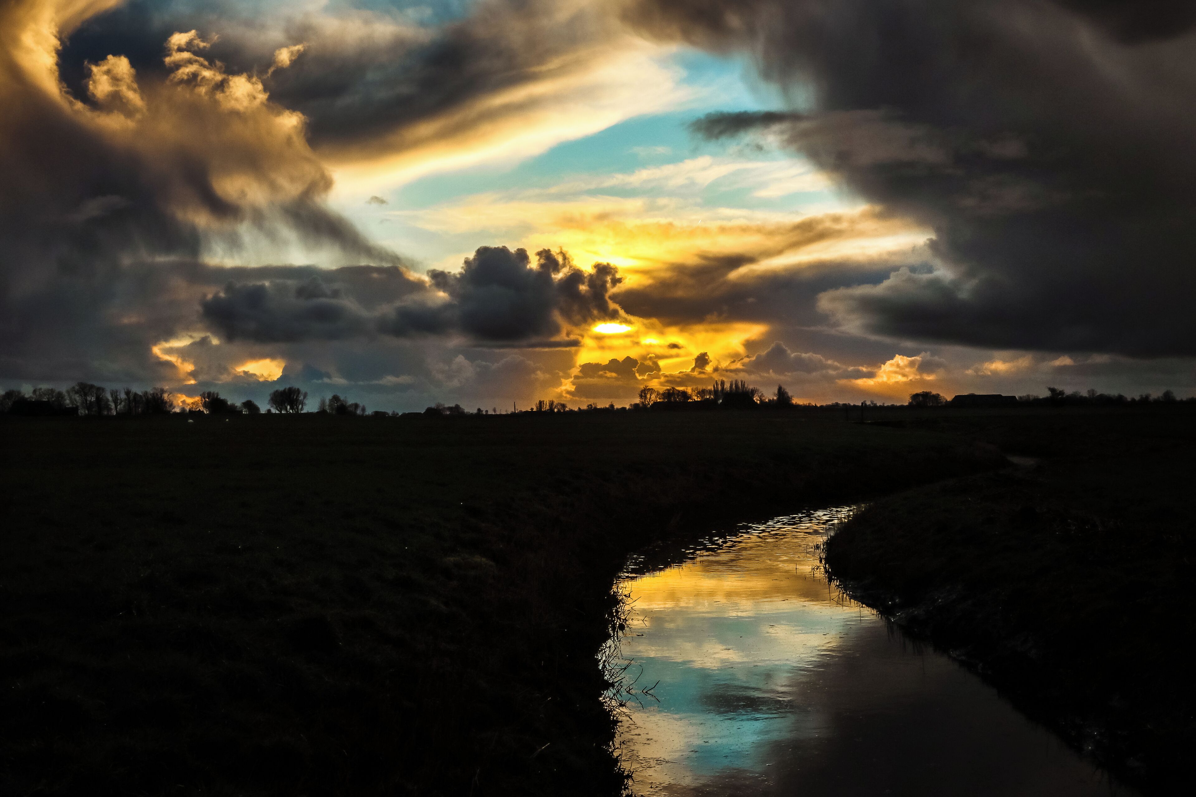 Ein Fluss, der den Himmel im Abendrot spiegelt.