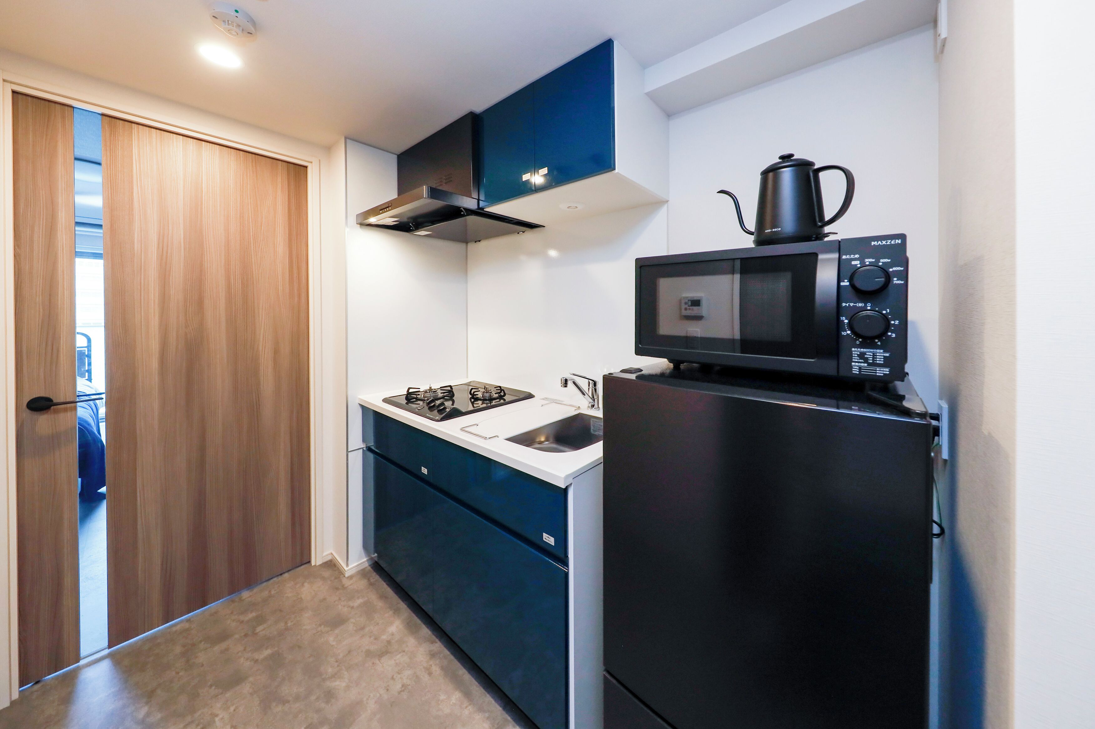 A compact kitchen with a microwave, stove, and refrigerator.