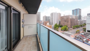 Un balcon avec vue sur la ville, une porte vitrée et une enseigne avec du texte en japonais.