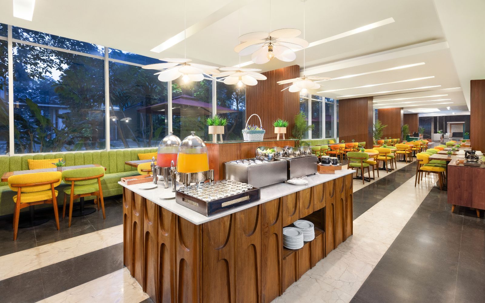 A modern cafe with a central serving counter, seating area, and large windows.