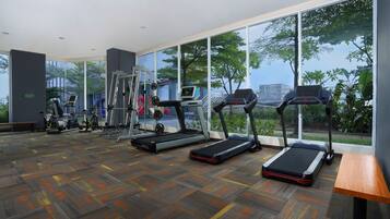 A gym with treadmills, elliptical machines, and weight equipment.