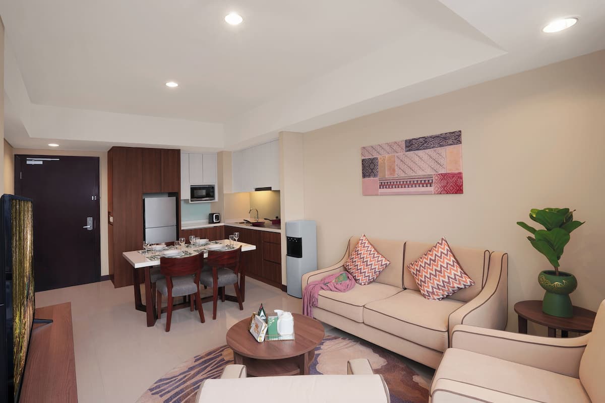 A modern living room with a sofa, coffee table, and dining area.