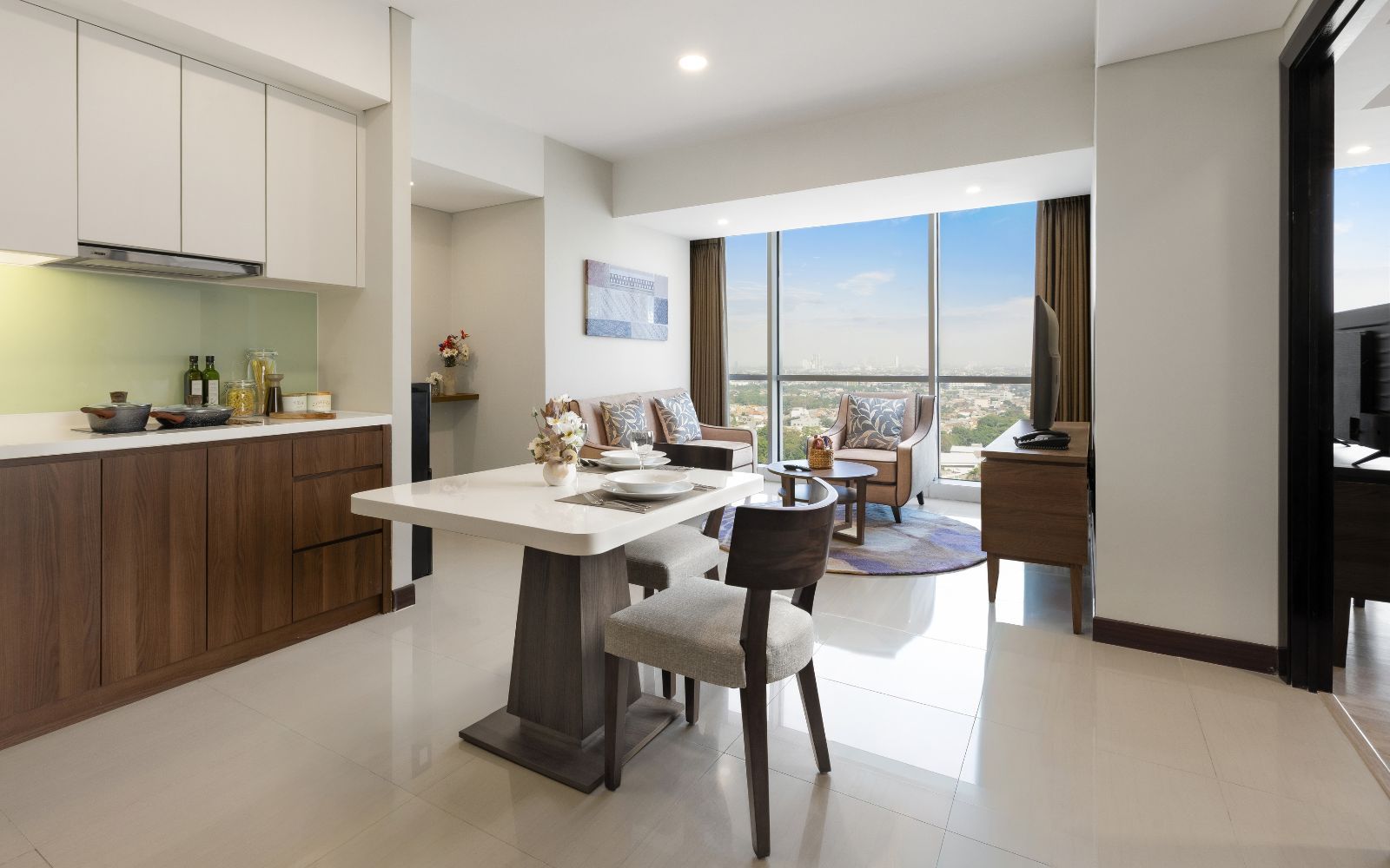 A modern kitchen with a dining area, large windows, and a view of the city.