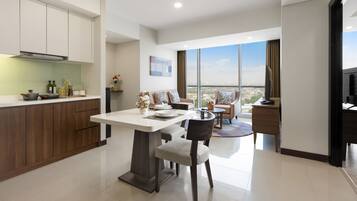 A modern kitchen with a dining area, large windows, and a view of the city.