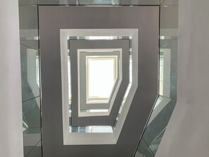 A modern interior with a geometric wall design and reflective surfaces. - MiVi (Lagos)