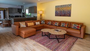 A modern living room with a sectional sofa, a coffee table, and a colorful rug. - Tranquil Escape: Private 4BR Pool Villa with Garden (Rawai)