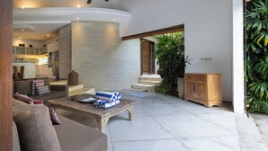 A modern living area with a sofa, coffee table, and wooden cabinet.
