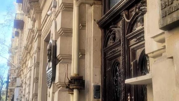 Ein historisches Gebäude mit einem auffälligen roten Schild für NH Hotel Nizhny Novgorod.