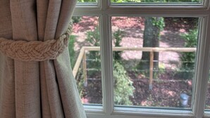 Ein Fenster mit Blick auf einen Baum und eine Holzterrasse.