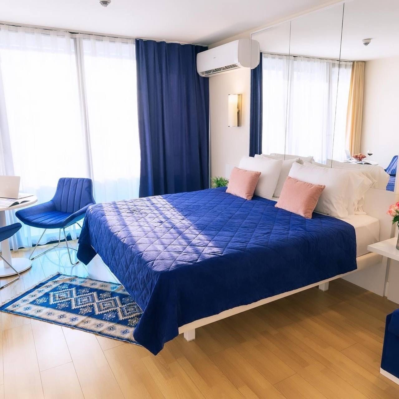 Una habitación de hotel moderna con una cama grande, un escritorio y una silla.