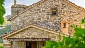 A stone building with a gabled roof, a small window, and a door. - Casa del Mandorlo 8 Emma Villas (Mercatello sul Metauro)