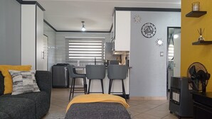 A compact living space with a sofa, a small dining area, and a kitchenette.