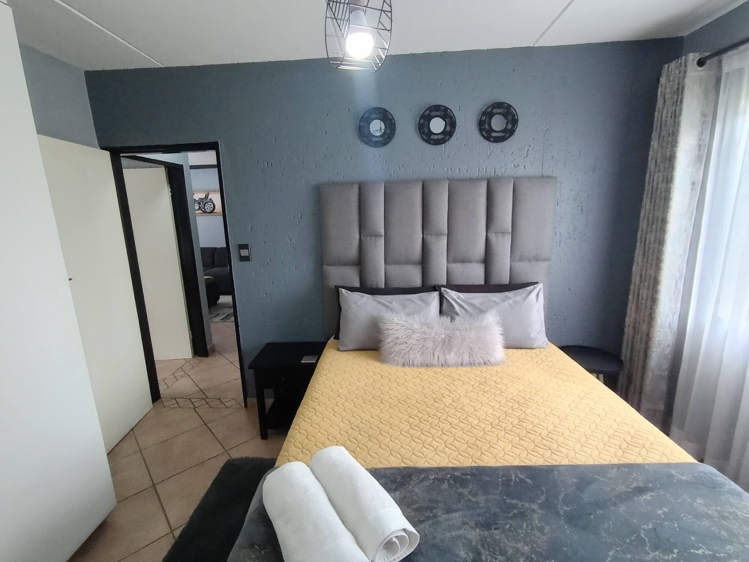 Ein Schlafzimmer mit einem großen Bett, einem Kopfteil und einem Nachttisch.