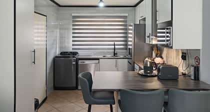 2 Bedroom apartment with 2 queen size beds & a cot, 10 minutes from JHB Airport.