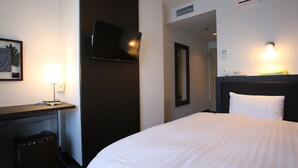 A hotel room with a bed, a desk with a lamp, a flat-screen TV, a mirror, and an air conditioning unit. - Hotel Crystal Plaza (Hitachinaka)